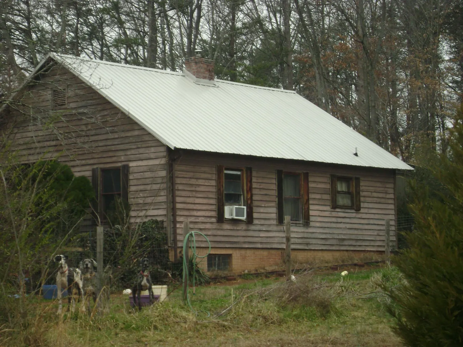 White metal roof on an old wood sided farmhouse, from a Metal Roof Installation job in Alma